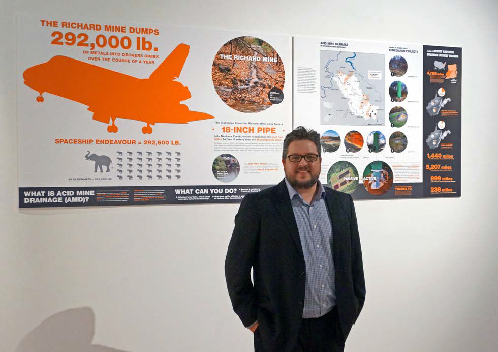 Forrest Conroy stands in front of one of the graphics that he created for FODC. 